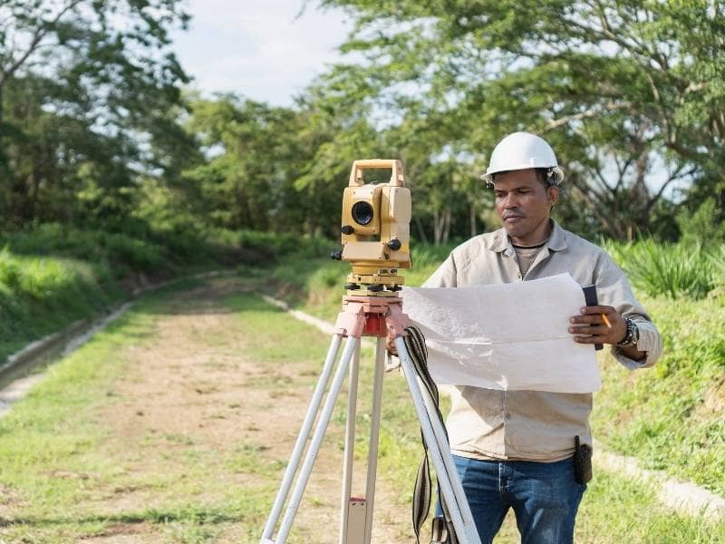 Land surveyor reviewing an old land survey to verify current property conditions