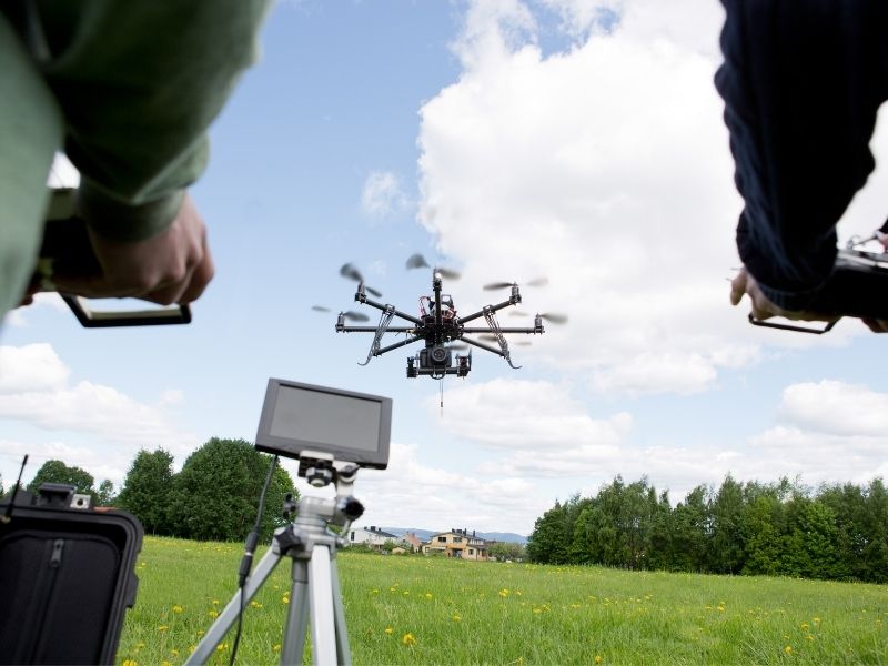 Survey professionals operating a drone to collect detailed mapping data across a property.