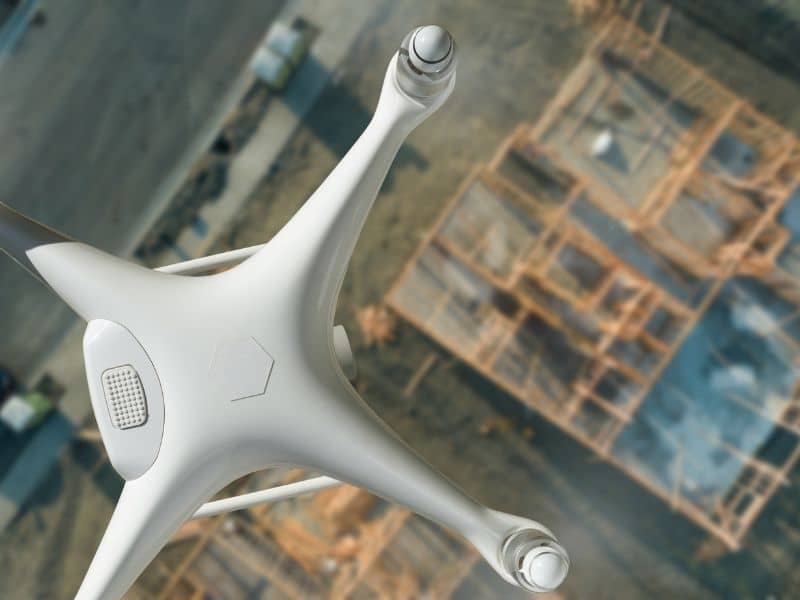 Drone flying above an active construction site to support aerial terrain scanning, site analysis, and construction layout planning.
